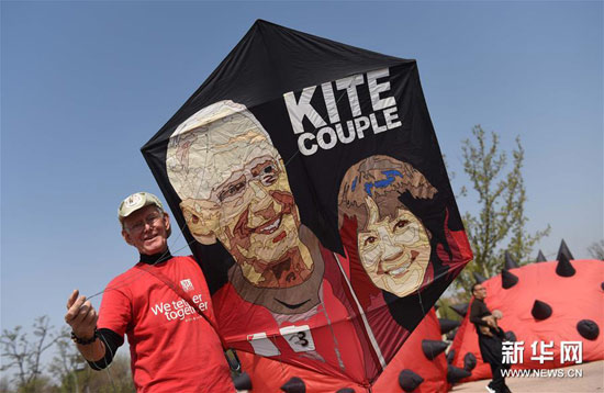 一名来自美国的风筝爱好者在展示印有自己和夫人头像的风筝。