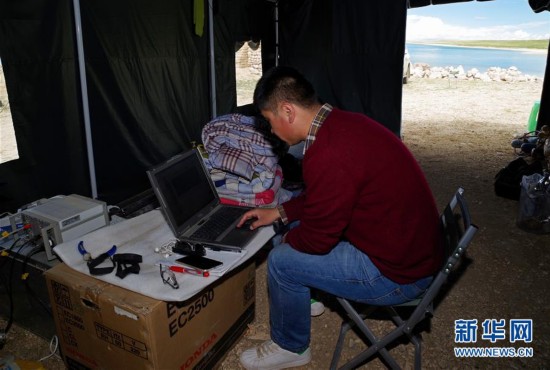 考察队成员孙根厚在色林错湖畔大营中处理探空气球传回的气象数据