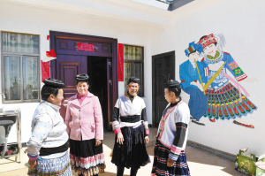 苗族妇女在新居前聊天。