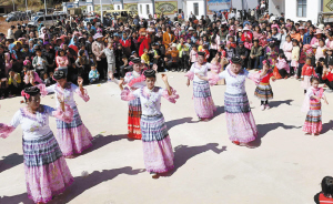 苗族群众在新居活动广场表演苗族舞蹈。