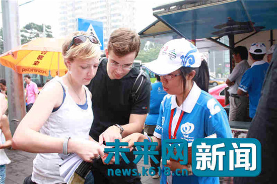 义务指路队中学生志愿者在认真帮助问路的外国友人。(东直门街道 供图) 义务指路队中学生志愿者在认真帮助问路的外国友人。(东直门街道 供图)