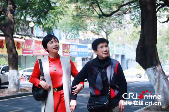 女儿牵着老人的手。李欣宏摄