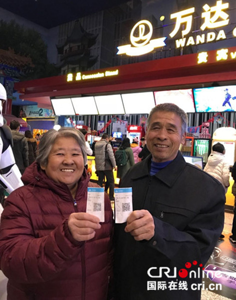 散场后，二老高兴地向记者展示票根。摄影：何雨阳