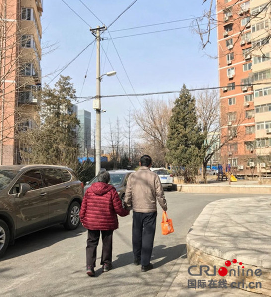 宋先生牵着老母亲的手一起散步。摄影：何雨阳