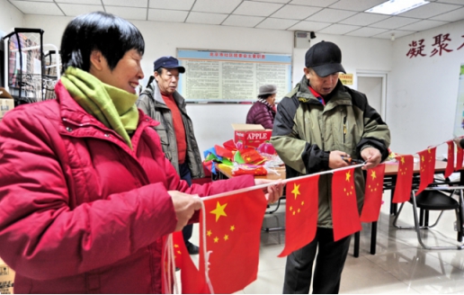 “巧巧手”志愿者帮扶队队员们正在制作灯笼和彩旗。