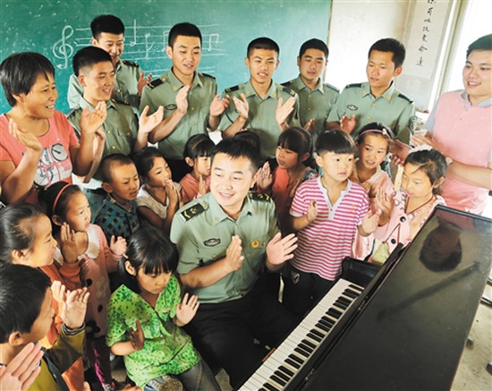 雷锋班战士为邱家窝棚小学的贫困学生募捐到一架钢琴，官兵与学生们同唱《学习雷锋好榜样》。 姜自恬摄