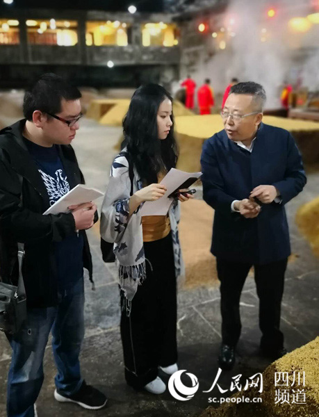 沈才洪（右一）向记者介绍酿酒过程。何孟书 摄