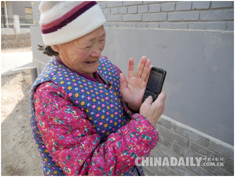 村民闻老太向记者展示手机里自己拍摄的花展照片 李雪晴/摄