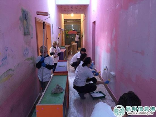 志愿者正在把福利院的墙刷成粉色。供图