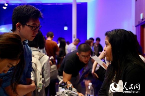 在领英海外人才招聘活动上，一名求职者（左）与企业代表进行交流。人民网张洁娴摄