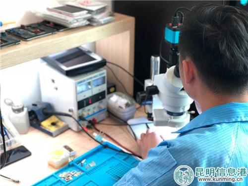 世纪城店手机维修工程师在进行手机芯片检查。记者马文焘摄
