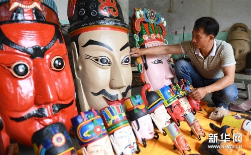 方文展在整理自己制作的毛南族傩面作品 方文展在整理自己制作的毛南族傩面作品
