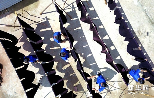 侗家妇女在鼓楼旁晾晒侗布