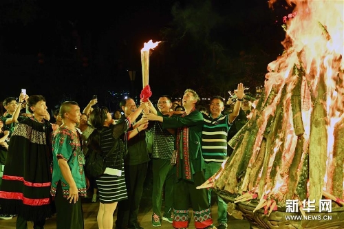 游客在云南楚雄彝人古镇点燃火把