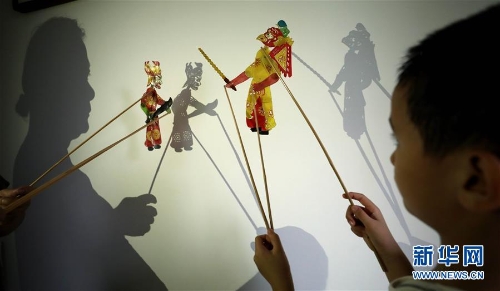 8月14日，李卫与外孙一起表演皮影戏。