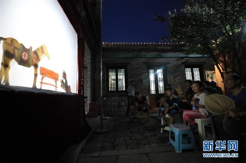 李卫在济南百花洲为市民表演皮影戏（7月15日摄）。