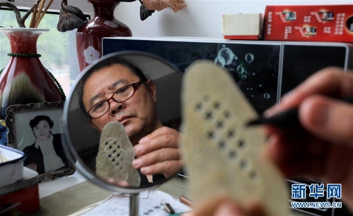 李卫在家中雕刻皮影人偶配件（7月11日摄）。