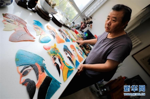 李卫展示自己制作的“济南名人脸谱”系列的皮影人偶（7月5日摄）。