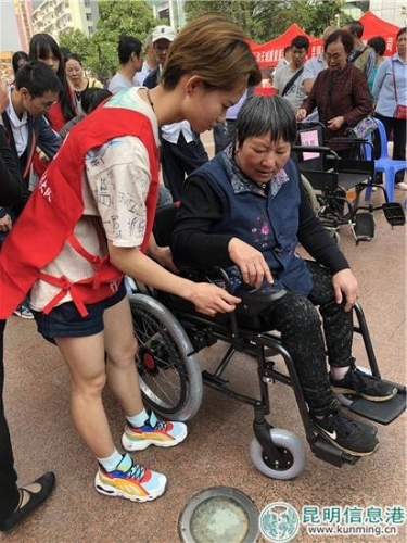 志愿者为残疾人代表讲解轮椅使用方法。