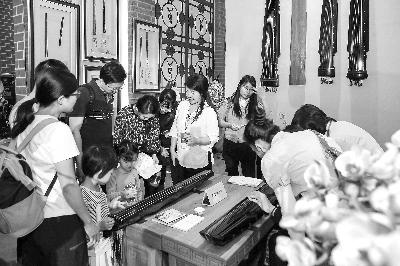 观众在非遗展区体验古琴弹奏    陈德欢 摄