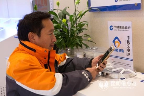 图四 李师傅在休息之余，赶紧给手机充电。