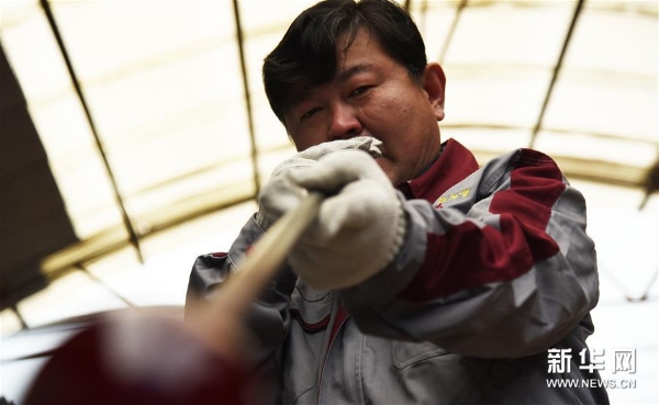 孙云毅在吹制鸡油黄琉璃艺术品