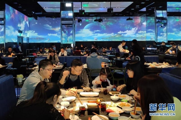 在北京海底捞智慧餐厅,食客们在声光沉浸式环境中享用火锅(1月30日手机拍摄)。 在北京海底捞智慧餐厅,食客们在声光沉浸式环境中享用火锅(1月30日手机拍摄)。