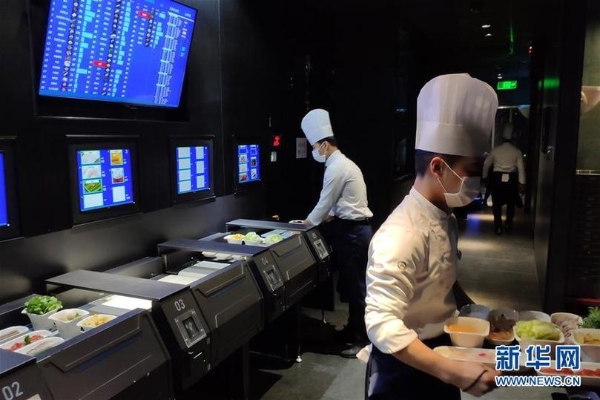 在北京海底捞智慧餐厅,员工在后厨工作(1月30日手机拍摄)。 在北京海底捞智慧餐厅,员工在后厨工作(1月30日手机拍摄)。