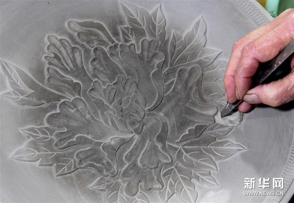 在位于河南省汝州市孟玉松的汝瓷生产车间内，孟玉松对制作完成的坯体进行雕刻（3月13日摄）。