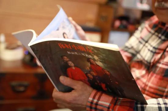 3月22日，在日本东京，秋山亮二在家中翻看自己的影集《你好小朋友》。新华社记者杜潇逸 摄