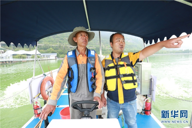在昆明滇池湖泊治理开发有限公司一线蓝藻打捞工人张文建看来，蓝藻治理就如愚公移山，不容易，不轻松，“不能半途而废，也不能仅凭一人。”（图右为张文建）（新华网 范芳钰 文 赵普凡 摄）