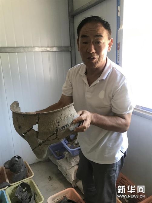 考古人员张官狮介绍陶寺遗址出土文物(8月13日摄)。 考古人员张官狮介绍陶寺遗址出土文物(8月13日摄)。