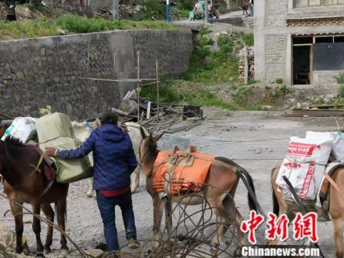 图为正在装东西的尼泊尔商队。 谢艺观 摄