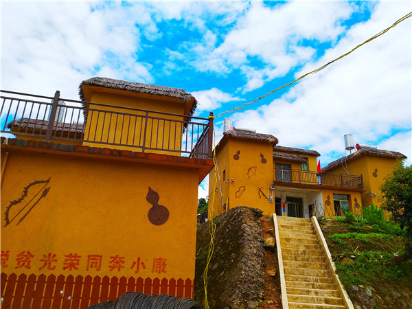 刷在拉祜寨墙上的标语：脱贫光荣同奔小康。记者江枫 摄