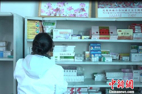 图为嘎宗卓玛正在医务室取药。 图为嘎宗卓玛正在医务室取药。