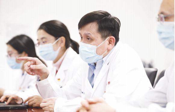 (张文宏与团队成员讨论分析目前疫情的趋势和防控方案)