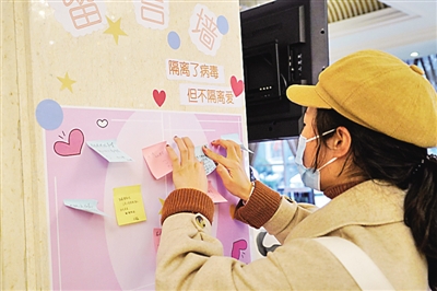 新年俗,“土味”中带着“潮”与暖 春节期间,一名结束医学观察的武汉滞留旅客在留言墙上写下感谢和祝福的话,传递信心力量。新华社发