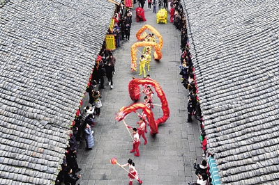 新年俗,“土味”中带着“潮”与暖 民间艺人在四川阆中古城表演舞龙舞狮。新华社发