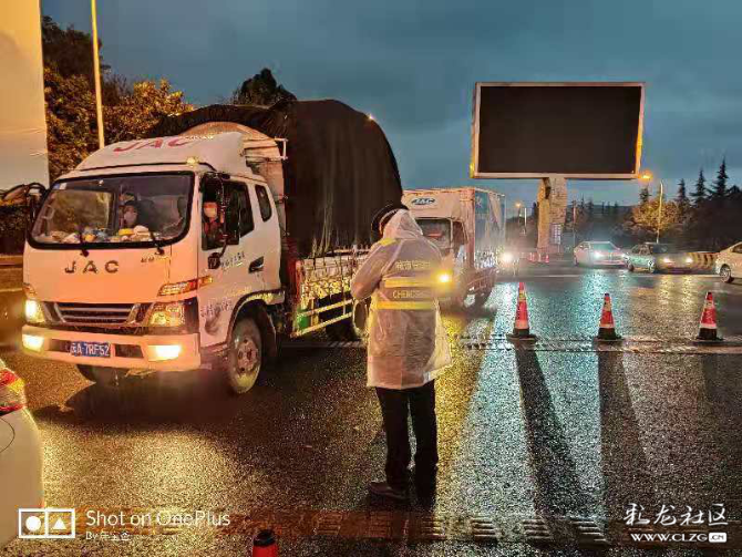 彩龙网友投稿作品：早上七点，雨越下越大，城管队员正在对车主测量体温、登记信息