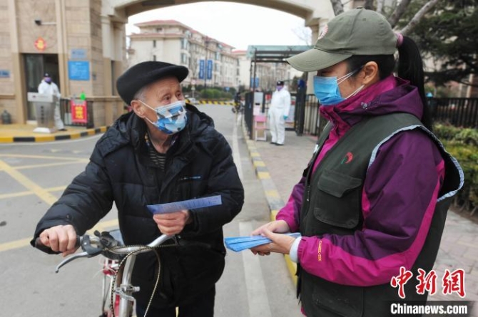 志愿者向社区居民发送“禁食野味”宣传单。　王海滨 摄