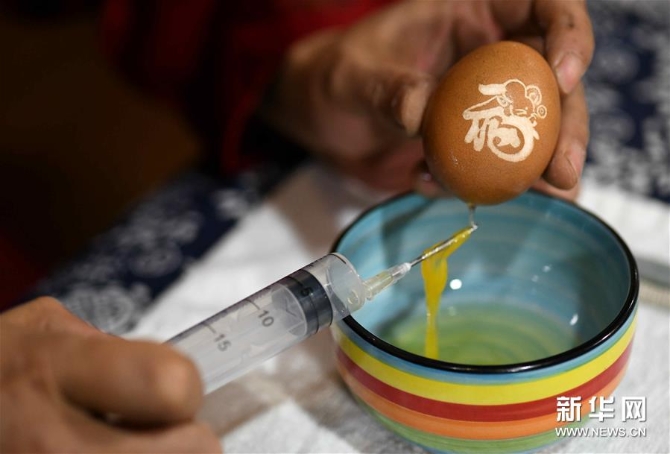 4月17日，在石家庄市桥西区非遗传承基地，民间艺人张晓贺用针管将蛋液取出。新华社发（陈其保 摄）
