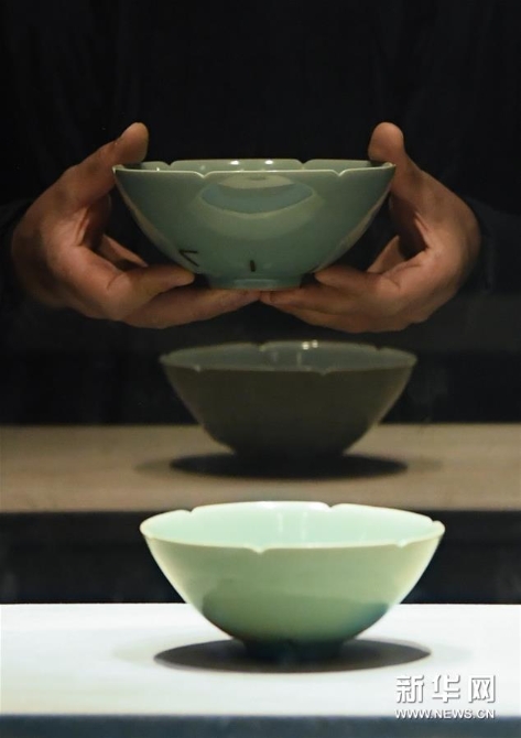 5刘杰在浙江博物馆将自己做的碗（上）和展出的南宋青瓷“马蝗绊”比较，以进行改进（2019年12月7日摄）。 新华社记者 翁忻旸 摄