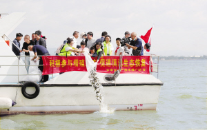 图为志愿者们将鱼苗投入滇池。记者李海曦摄 图为志愿者们将鱼苗投入滇池。记者李海曦摄