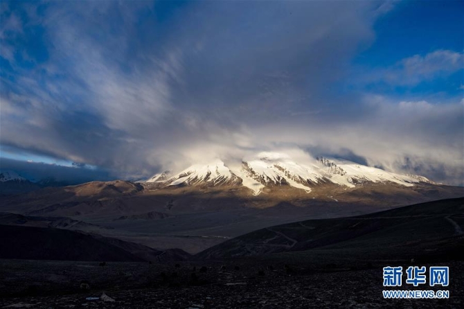 b帕米尔高原上，夕阳下的慕士塔格峰（6月15日摄）。 夏日，新疆帕米尔高原上，连绵的雪山、湛蓝的湖泊和如茵的草地交相辉映，呈现出壮美的生态画卷。 新华社记者 胡虎虎 摄