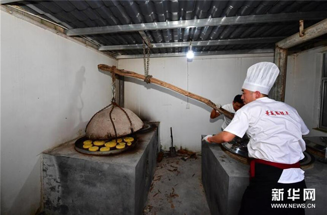 9月13日,在河南省商丘市夏邑县太平镇聂陈楼村,张旭(右)将月饼上炉。新华社记者 冯大鹏 摄 9月13日,在河南省商丘市夏邑县太平镇聂陈楼村,张旭(右)将月饼上炉。新华社记者 冯大鹏 摄