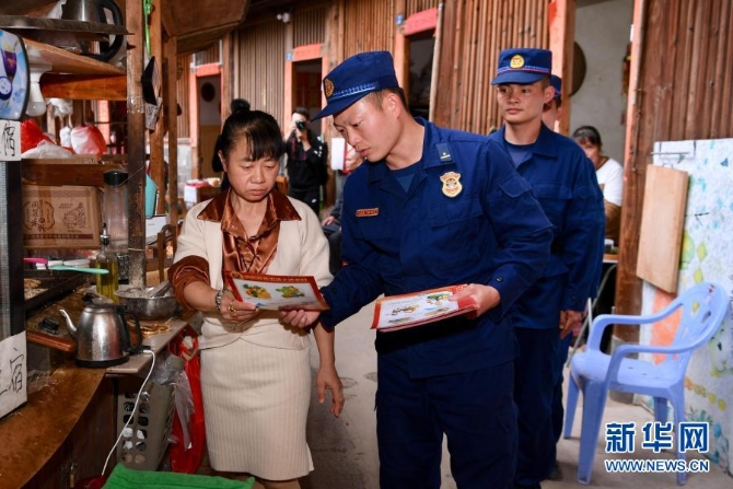 12月10日，福建省南靖县土楼消防救援站指战员在土楼怀远楼内巡查时向居民发放消防安全宣传单。