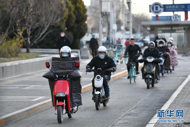 12月29日，行人骑车经过北京宣武门路口。当日，入冬最强寒潮来袭，多地迎来今冬最寒冷天气。新华社记者 李鑫 摄