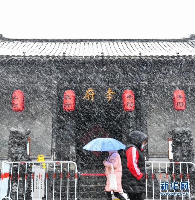 12月29日，在安徽省合肥市，行人冒雪走过李鸿章故居。当日，入冬最强寒潮来袭，多地迎来今冬最寒冷天气。新华社记者 韩旭摄