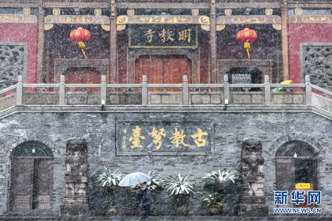 12月29日，在安徽省合肥市，行人冒雪走过明教寺。当日，入冬最强寒潮来袭，多地迎来今冬最寒冷天气。新华社记者 韩旭摄