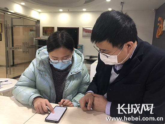 工作人员正在微信平台上为企业预约市场服务综合业务的办理时间。实习记者 张佳 摄
